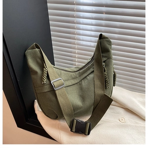 Detail of olive green corduroy fabric texture and adjustable strap on crossbody bag