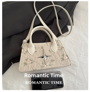 Detailed view of cream straw bag with floral embroidery and smartphone size comparison