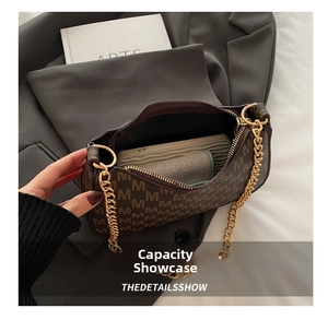 Brown moon bag with M-letter print showing interior space for phone and wallet