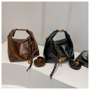 Detail of vintage dumpling bags in brown and black leather with woven drawstring accents