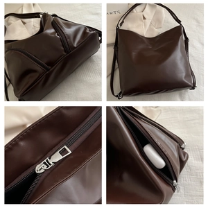 Detail of dark brown PU leather bag showing double zipper pockets and soft matte texture