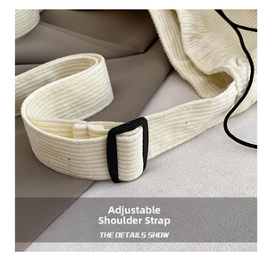 Close-up of adjustable strap on white corduroy tote bag with black buckle details