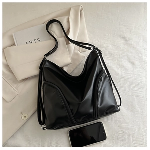 Detail of a black versatile leather backpack with zipper pockets and large capacity