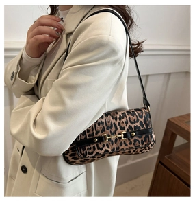 Close-up of leopard print shoulder bag featuring a decorative gold horsebit buckle