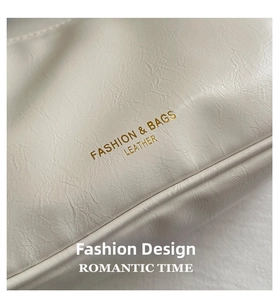 Detail of white lychee grain leather bag featuring gold foil fashion text and fine stitching
