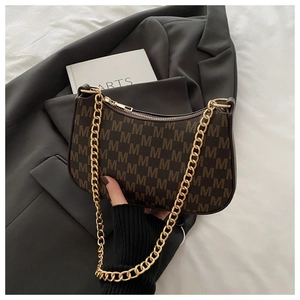 Detailed close-up of dark brown M-letter print handbag with golden chain strap