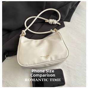 Detail of cream white leather half-moon bag with knot strap and gold hardware