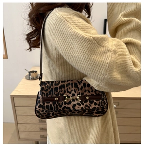 Detailed view of leopard print shoulder bag featuring a gold metal horsebit buckle decoration