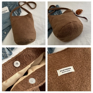 Detail of brown teddy wool bucket bag featuring silver magnetic closure and teddy charm
