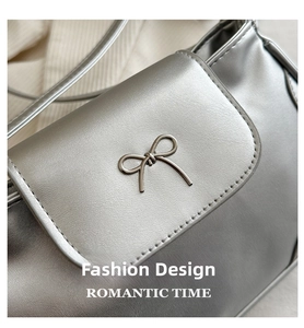 Close-up of metallic silver shoulder bag with refined metal bow detail and clean stitching