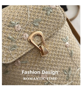 Détail du sac en paille tressée avec broderie florale rose et boucle en métal doré