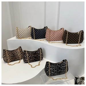 Detail of crescent hobo bags in vintage logo print and leopard patterns with gold chains