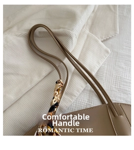 Close-up of brown PU leather bag handle with a colorful decorative floral silk scarf