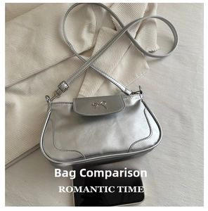 Detail view of silver leather phone bag with metal bow buckle and a smartphone for scale