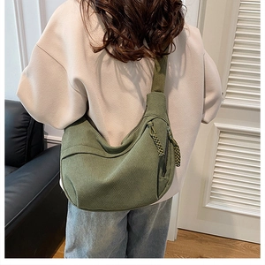 Detail of avocado green corduroy bag showing soft texture and woven zipper pullers