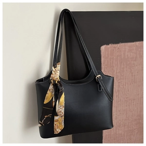 Detail of minimalist black tote bag featuring white contrast stitching and silk scarf accessory