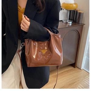 Borsa marrone in pelle sintetica con placca in metallo e tracolla regolabile