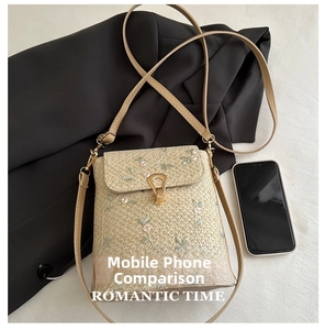 Détail du mini sac bandoulière en paille avec broderie florale et boucle dorée en U