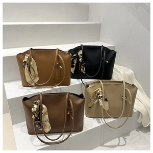 Detail view of four leather tote bags in assorted colors with floral silk scarf accents