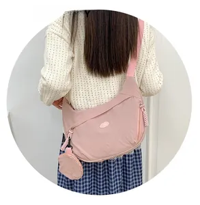 Pink nylon crescent bag detail showing wide fabric strap and matching round coin purse