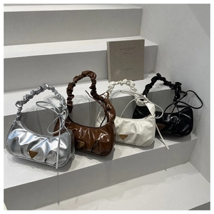 Detailansicht der gerafften Schultertaschen in Silber, Braun, Cremeweiß und Schwarz auf Stufen