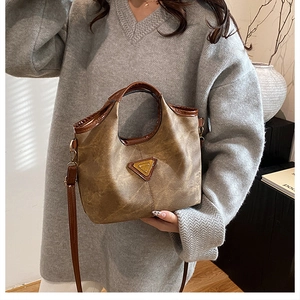 Dettaglio della borsa tote vintage con logo a triangolo oro e manici a contrasto