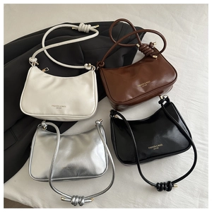 Top view of minimalist leather underarm bags in white, brown, silver, and black colors