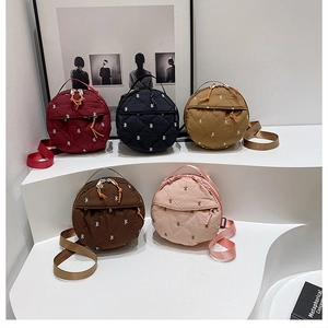 Detailed view of quilted circular crossbody bags in five colors with bow embroidery