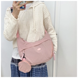 Pink nylon crescent crossbody bag with matching round coin purse detail on strap