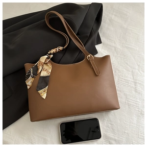 Brown PU leather tote bag with printed silk scarf and adjustable strap next to a smartphone