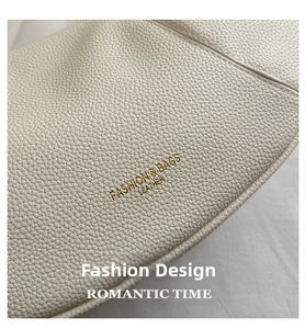 Detailed macro view of off-white lychee grain leather with golden logo embossing