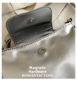 Detailed view of silver crossbody bag featuring a durable magnetic buckle closure
