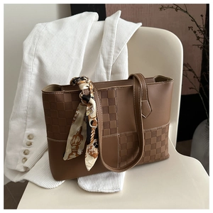 Brown tote bag detail with textured checkerboard pattern and silk scarf handle