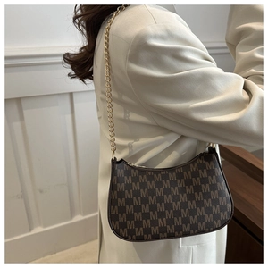 Detail of retro crescent underarm bag with letter M monogram print and gold chain strap
