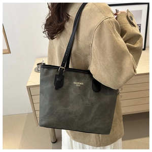 Detail shot of the large dark grey tote bag with slim black straps on a shoulder