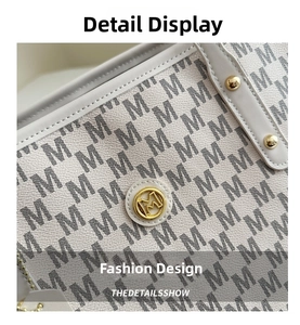 Close-up of M-patterned fabric with litchi grain leather trim and golden metal logo