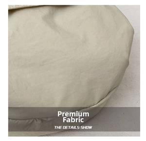 Macro shot of durable nylon fabric texture on beige crossbody bag showing detail