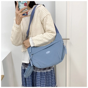 Morandi blue nylon crescent bag with wide strap and mini round coin pouch detail