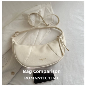 Detail of off-white dumpling bag with litchi grain texture and gold fashion lettering