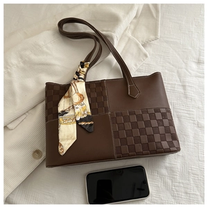 Detail of dark brown leather tote bag with silk scarf and phone for size reference