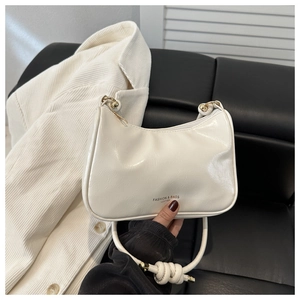 Detail of white glossy leather hobo bag with gold metal ball and knotted strap detail