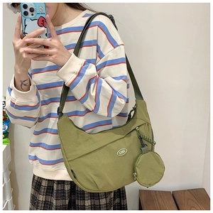 Mirror selfie showing the large nylon crescent crossbody bag with a round coin purse