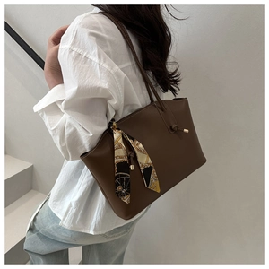 Detail of dark brown tote bag with decorative geometric silk scarf and topstitching