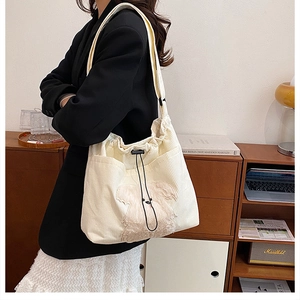 Detailed texture of off-white corduroy tote bag featuring a 3D plush puppy patch