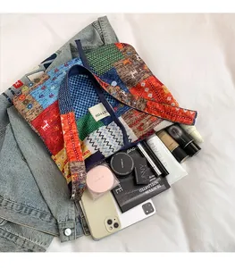 Detail of multi-color patchwork tote bag with blue handles and unique ethnic fabric patterns