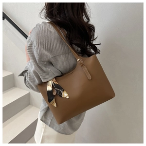 Brown PU leather tote bag with silk scarf detail shown on shoulder in minimalist setting