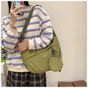 Detail view of large olive nylon crossbody bag with detachable round coin purse