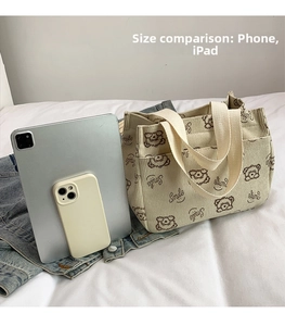 Confronto dimensioni borsa tote in velluto a coste con uno smartphone e un tablet piatto