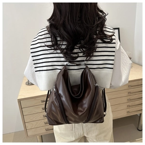 Detail of soft dark brown leather backpack with silver zippers and large capacity