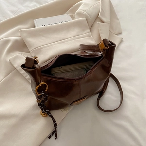 Deep brown faux leather hobo shoulder bag with metal logo and woven knot accessory